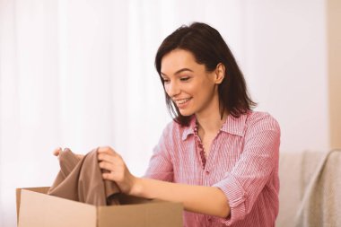 Teslimat, Nakliye ve Posta Servisi Konsepti. Mutlu genç Amerikalı kadın elinde karton bir kutu tutuyor.