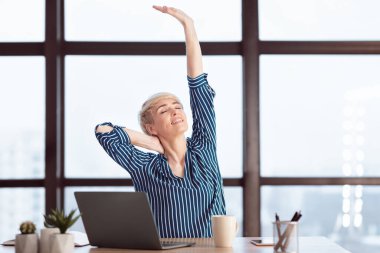 Female Entrepreneur At Laptop Stretching Hands Having Break Relaxing At Work Sitting In Modern Office. Selective Focus