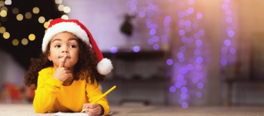 Noel dileği. Düşünceli Afrikalı Amerikalı kız Noel Baba 'dan ne isteyeceğini düşünüyor.