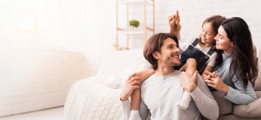 Evde mutlu bir aile, oturma odasında birlikte oynuyor.
