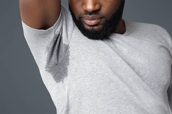 Молодой афро-человек нюхает свою мокрую подмышку, закрывается, пустое место
