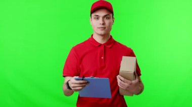 Kırmızı üniformalı bir teslimatçı, elinde karton bir kutuyla parlak yeşil bir arka planda duran bir pano üzerindeki bilgileri kontrol ediyor. Ayarlar teslimat için bir hazırlık olduğunu gösteriyor..