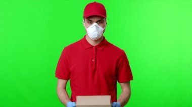 Eldiven ve maske takan bir dağıtım işçisi yeşil bir zemine karşı durarak, izleyiciye odaklanmış bir ifadeyle bir paket uzatıyor. Ayarlar profesyonel bir servisi yansıtıyor.