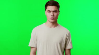 Genç bir adam, canlı yeşil bir arka plana el hareketleriyle dokunaklı bir duruş sergiliyor. Odaklanmış ifadesi onun konuşmayla ya da oyunculukla meşgul olduğunu gösteriyor..