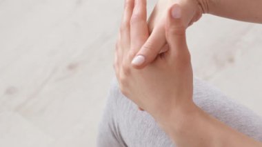 Bir insan evinde, elinde bir damla nemlendirici tutarak rahatça oturur. Rahatlamış atmosfer, bir anlık yansıma ya da kişisel bakım göstergesi..