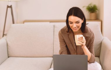 Serbest çalışıyorum. Dizüstü bilgisayarda çalışan, evinde oturmuş çay içen, fotokopi çeken sıradan, güzel bir genç kadın.