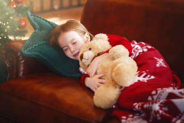 Küçük kız parlayan Xmas ağacının yanında uyuyor, oyuncak ayıya sarılıyor, sihirli şeyler Noel gecesi oluyor, boş yer.