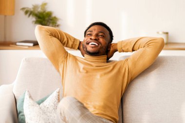 Hafta sonu evde. Afro Adam 'ın koltukta oturup ellerini içeride tutarak rahatlamasını dilerim. Boşluğu Kopyala