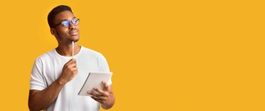 Dalgın Reaktör. Gözlüklü Afro Adam 'ın notlar aldığını, fikirler yazdığını, boşluğa, turuncu duvara, panorama' ya baktığını gördüm.