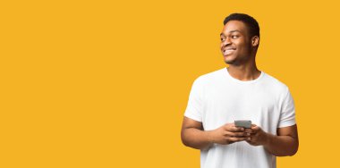 Gülümseyen Siyah Adam 'ın cep telefonunun yakın plan portresi Kopya Boşluğu, Panorama, Turuncu Stüdyo