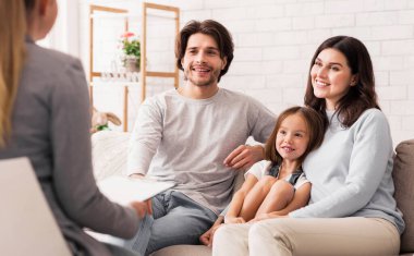 Başarılı bir aile terapisinden sonra Küçük Kızlı Mutlu Ebeveynler Psikologlar Ofisi 'nde birlikte oturuyorlar.