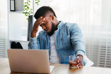 İş sorunları. Ofiste alkol alan depresyondaki siyahi işadamı, mali sorunları var..