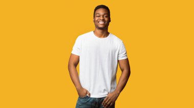 Kendine güvenen adam. Portakal rengi stüdyo arka planında el ele duran Afro-Amerikan adam portresi.