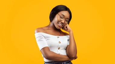 Gorgeous African American Millennial Lady Smiling At Camera Posing Touching Chin Standing In Studio On Orange Background. Panorama