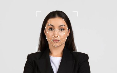 Bir kadın, tarafsız bir stüdyo arka planında yüz tanıma grafiğiyle kendinden emin bir şekilde durur..