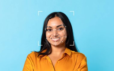 Hintli bir kadın yüzünde, parlak mavi bir arkaplan karşısında duran yüz tanıma kalıplarıyla güvenle gülümsüyor..