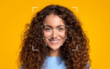 Kıvırcık saçlı bir kadın, yüzünde canlı sarı bir arka plana karşı bir yüz tanıma şekli oluştururken ışıl ışıl gülümsüyor..