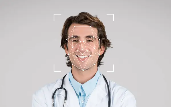 stock image A doctor wearing a lab coat and stethoscope smiles confidently, surrounded by a light neutral background.