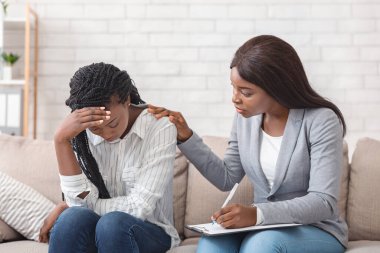 Kadın psikolog, ofisteki terapide depresyondaki siyahi kadını teselli ediyor ve sorunlarını paylaşması için ona destek oluyor.