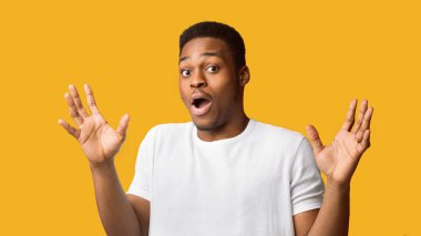 Bu ben değilim. Kafası karışmış siyah adam ellerini kaldırıyor ve kameraya bakıyor, turuncu stüdyo duvarı, telif alanı, panorama