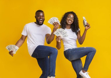 Ellerinde para ile dans Afrikalı Amerikalı neşeli çift, bacaklarını yukarı kaldırarak