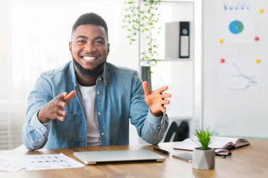 Gülümseyen Afro-Amerikan iş koçu kameradaki deneyimini ve yaratıcı fikirlerini paylaşıyor, başarılı çalışma stratejileri hakkında konuşuyor, kopyalama alanı hakkında konuşuyor.