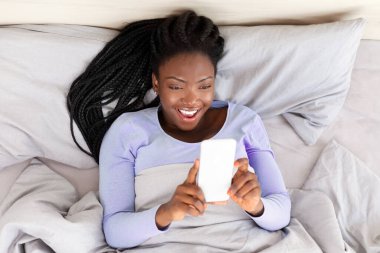 Hapy Afro-Amerikalı kız evde yatakta uzanmış el ele tutuşuyor. Sabah Sohbeti. Görünümün Üzerinde Seçici Odaklanma