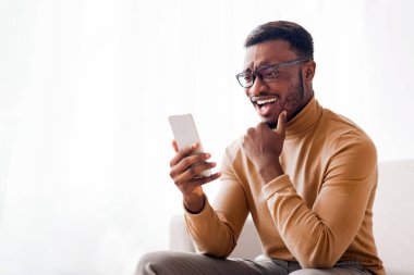 Mutlu Siyahi Adam Cep Telefonu Mesajlaşması, İnternette Sohbet Oturan Kapalı Oda 'da. Modern İletişim