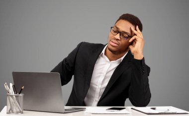 İşteki sorunlar. Siyah iş adamı üzgün ve çaresiz hissediyor, bilgisayara bakıyor, ofiste çalışıyor. Boş alan