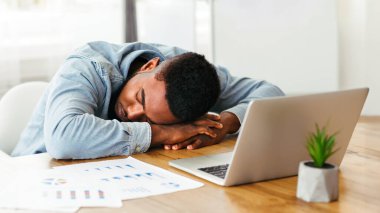 İşte uyuyorum. Yorgun Afro-Amerikan çalışanı iş yerinde kestiriyor, panorama