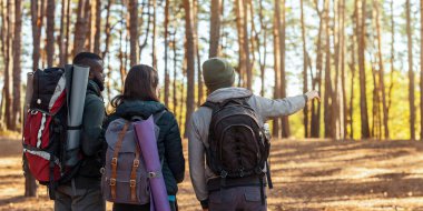 Ormandan geçen uluslararası arkadaş yürüyüşçülerin, fotokopi alanını ve panoramasını gösteren adamın