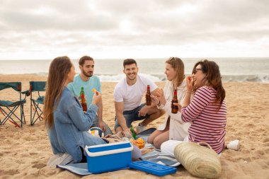 Beş arkadaştan oluşan bir grup kumsalda gevşeyip abur cubur ve içecekleri paylaşır. Güneş ufukta batarken birbirlerine eşlik edip eğlenirler..