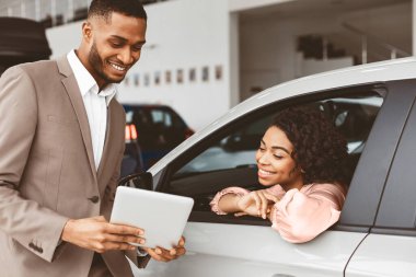 Afro-Amerikalı Kadın Araba Satın Alma, Satış elemanı Otomobil galerisinde Evrak ve Belge Gösterme Teklifi.