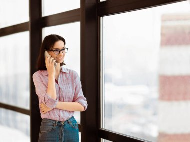 Aileyi arıyorum. Akrabalarına telefon eden ya da erkek arkadaşını arayan mutlu kız öğrencinin portresini yakın plan çek. Boş alan