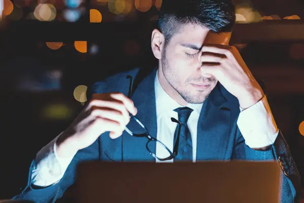 stock image Businessman Having Headache Massaging Nosebridge Holding Glasses, Tired Of Overtime Work At Laptop In Modern Office At Night. Selective Focus