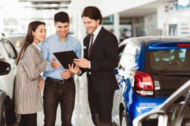 Araba kiralama. Yakışıklı Satıcı Çift Otomobil Teklif, Pano Gösterme, Oto Kiralama Ofisinde Durma