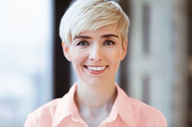 Neşeli Olgun Kadın Pencereye Karşı Gülümsüyor. Kadın Girişimciler Portresi. Seçici Odaklanma, Boş Alan