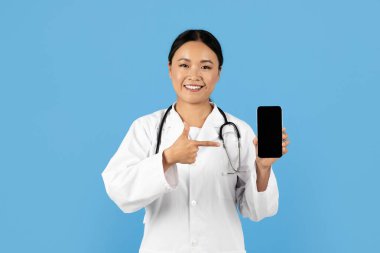 Profesyonel bir Asyalı kadın elindeki akıllı telefonu işaret ederken gülümsüyor. Üzerinde beyaz bir laboratuvar önlüğü ve steteskop var.