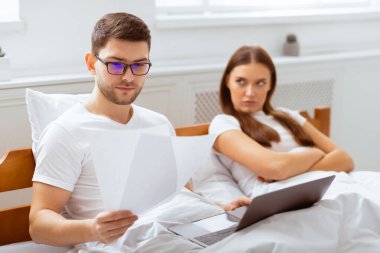 Dizüstü bilgisayarda çalışan, yatak odasında suç işleyen kız arkadaşıyla yatan bir erkek arkadaş. Modern İlişki Sorunları. Seçici Odaklanma