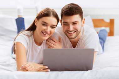 Erkek arkadaş ve kız arkadaş dizüstü bilgisayarla yatıp yatak odasında film izliyorlar. Birlikte hafta sonu. Seçici Odaklanma