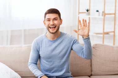 Hoş geldiniz. Neşeli adam el sallıyor. Gülümsüyor. Kameraya bakıyor..