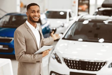 Lüks Otomobil Fuarı sırasında Gıcır gıcır Duran Yeni Otomobil Gösteren Neşeli Araba Satıcısı. Boş Boşluk