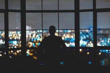 Modern Ofiste Gece Şehir Manzaralı Panoramik Pencerenin Yakınındaki Kameraya Bekleyen İşadamı.