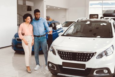 Araba Satın Alma. Afro Koca, Satış Salonunda Karısına Yeni Otomobil Duruşmasını Gösteriyor. Tam Uzunluk, Boşluğu Kopyala