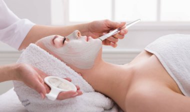 Yüz soyma maskesi, kaplıca güzellik tedavisi, cilt bakımı. Güzellik salonundaki kadın yüz bakımını alıyor. Yan görüş, yakın çekim.