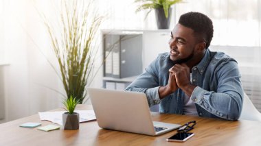 Modern ofiste çalışırken bir şeyin hayalini kuran dalgın siyahi girişimci, boşluğu kopyala