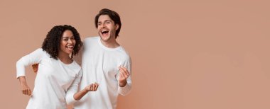 Playful Mood. Joyful Interracial Couple Having Fun, Dancing And Fooling Together Over Yellow Background In Studio, Empty Space