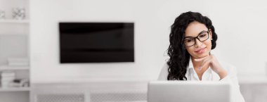 İş kariyeri. Gülümseyen Meksikalı kadın dizüstü bilgisayar kullanıyor modern ofiste oturuyor, boşluğu kopyalıyor.