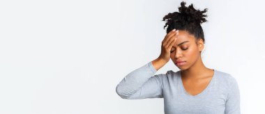 Ateşli hasta zenci kadın, alnına dokunuyor, gri stüdyo geçmişi var.