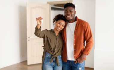 Gayrimenkul. Neşeli Afro-Amerikan eşleri, Yeni Ev Anahtarlarını Kameraya Gösteriyor, Evde Karton Kutuların Arasında Kucaklıyor. Taşınma, Apartman Sahibi ve Aile Konutları